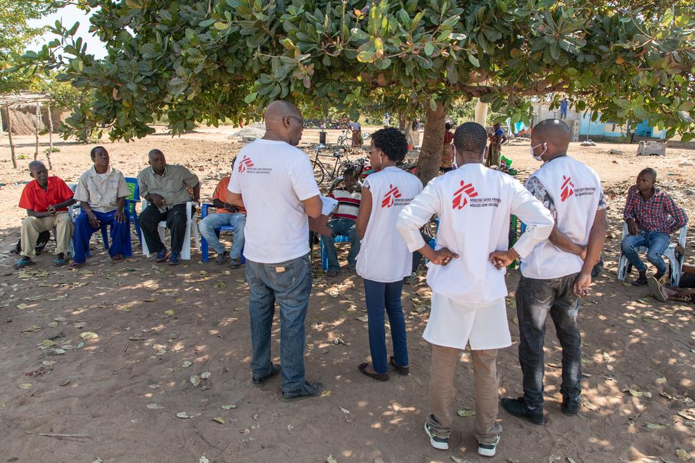 Medical professional in red MSF vest attending to patients in a clinic setting in Kenya, bright daylight
